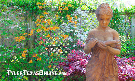 Statue with yellow azaleas  along the Tyler Azalea Trails in East Texas